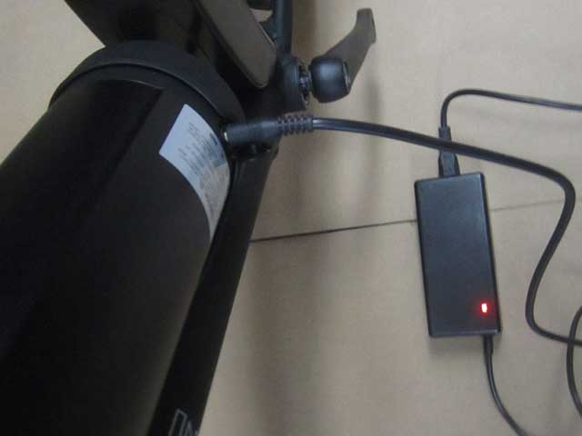 Plug the charger into the battery, then into the wall outlet. You can charge your battery on or off the bike. The charger will turn green when fully charged.